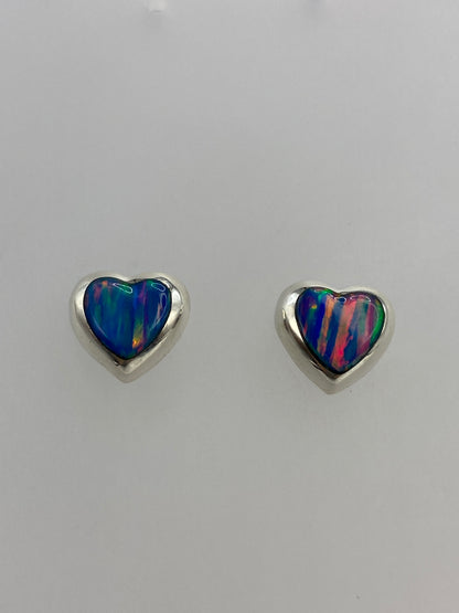 Detalle de los aretes mostrando los reflejos de fuego rojo, naranja y azul del ópalo engastado