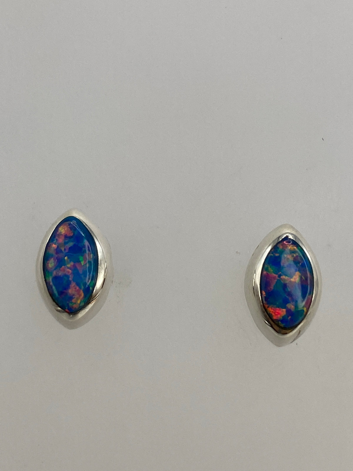 Aretes mostrados con regla de centímetros para escala de tamaño