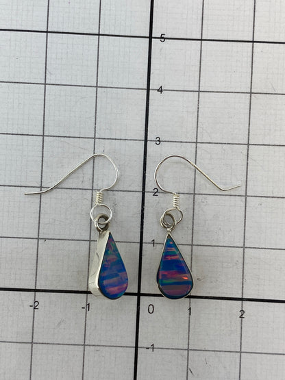 Ópal de fuego multicolor en aretes de plata Taxco sobre fondo blanco