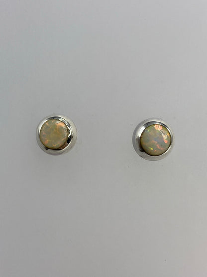 Par de aretes de plata 925 con ópalo de fuego blanco, vistos de frente sobre fondo blanco