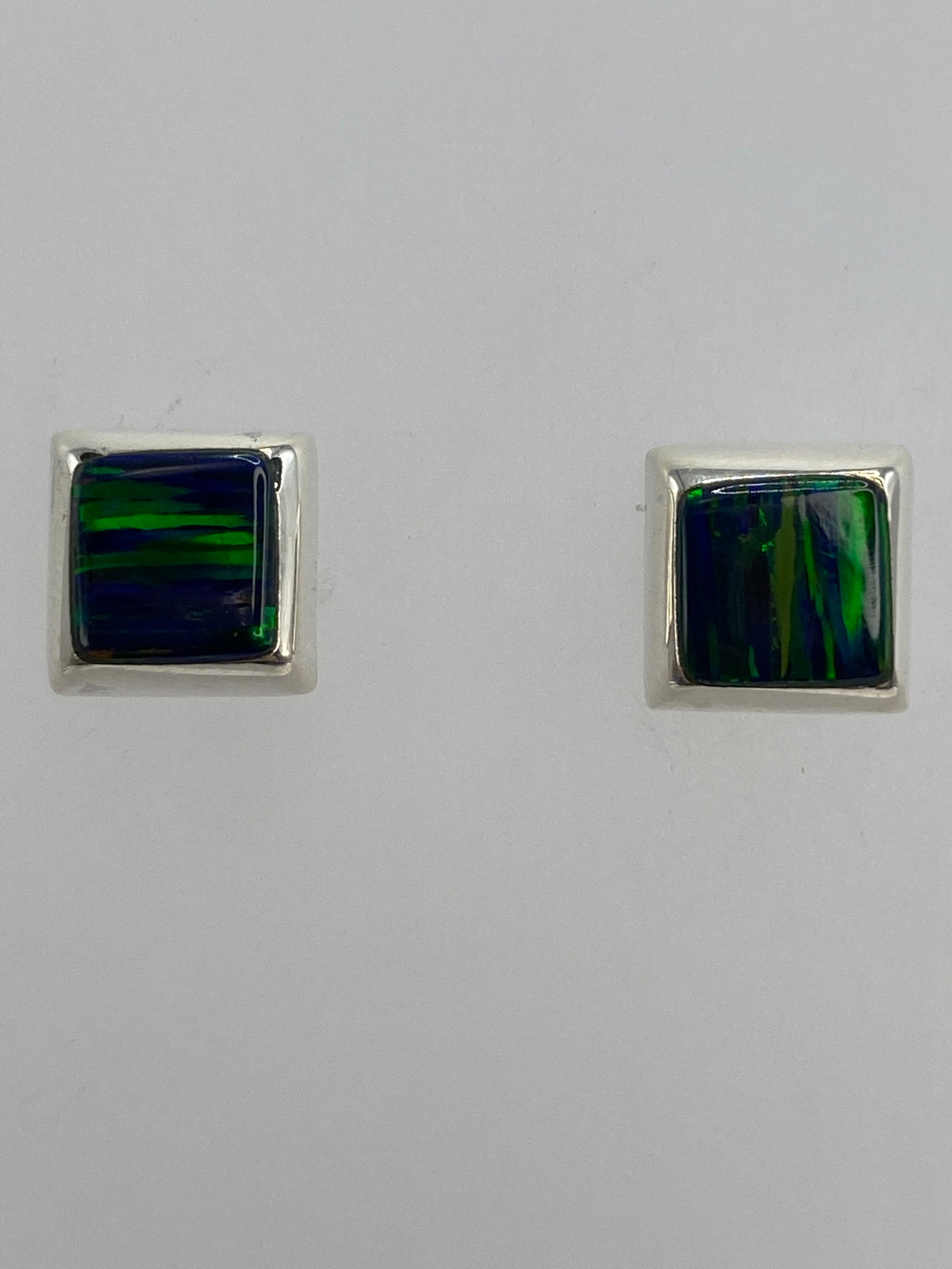 Aretes vistos de lado, mostrando el poste y el juego de colores del ópalo