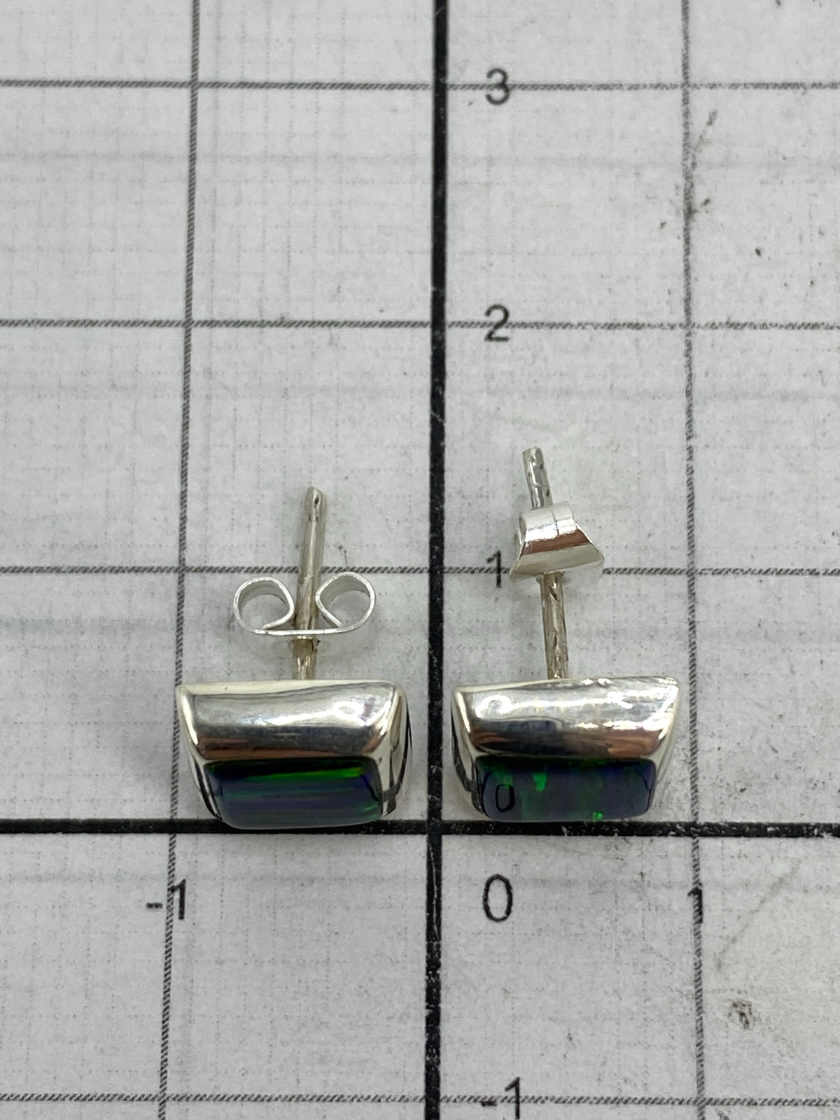 Aretes con medida en centímetros, mostrando tamaño delicado de 1.3 cm
