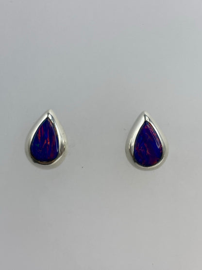 Par de aretes de plata 925 con ópalo de fuego morado, vistos de frente sobre fondo blanco