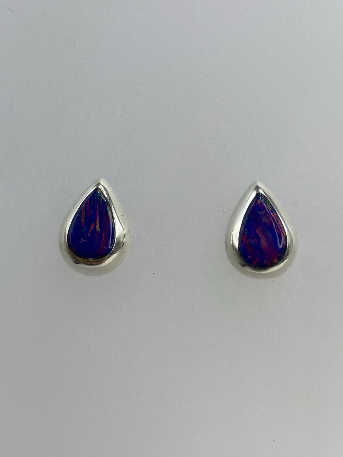 Detalle del ópalo de fuego morado engastado en plata, mostrando los reflejos profundos de la piedra