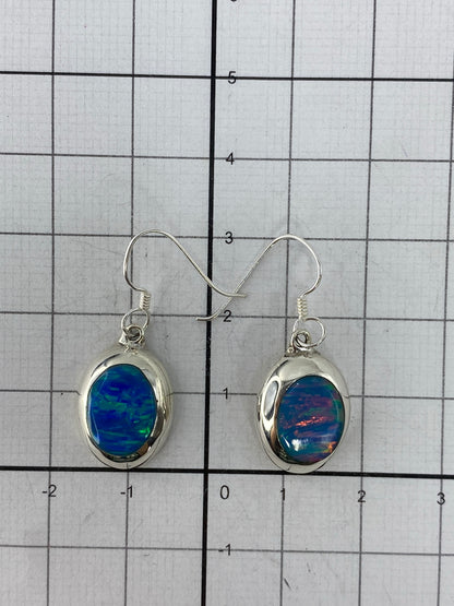 Aretes colgando de gancho de plata mostrando el Quinto 925