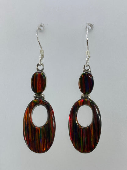 Detalle del opalo de fuego multicolor en los aretes de plata de Taxco