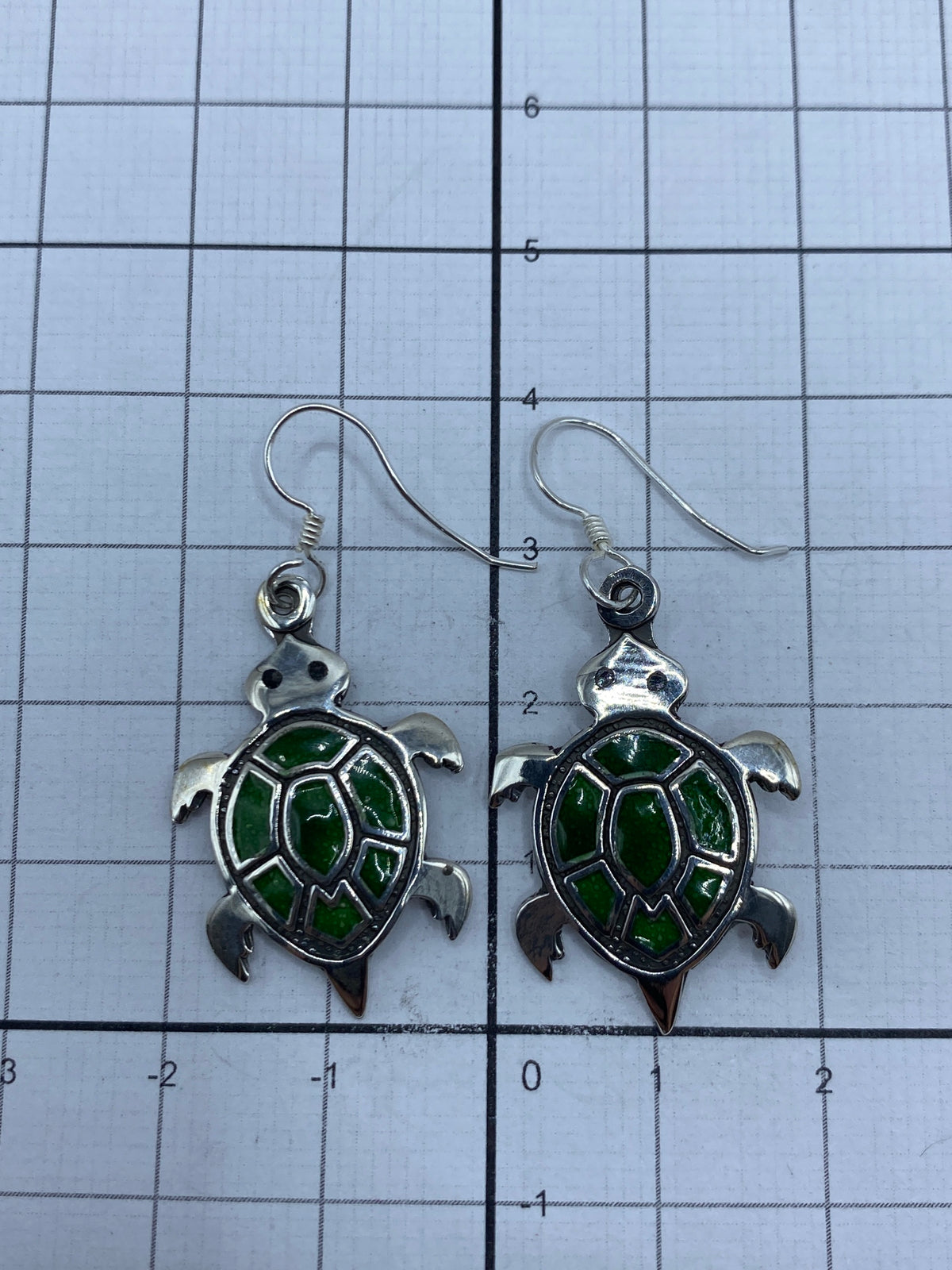 Par de aretes tortuga sobre fondo blanco mostrando el Quinto 925