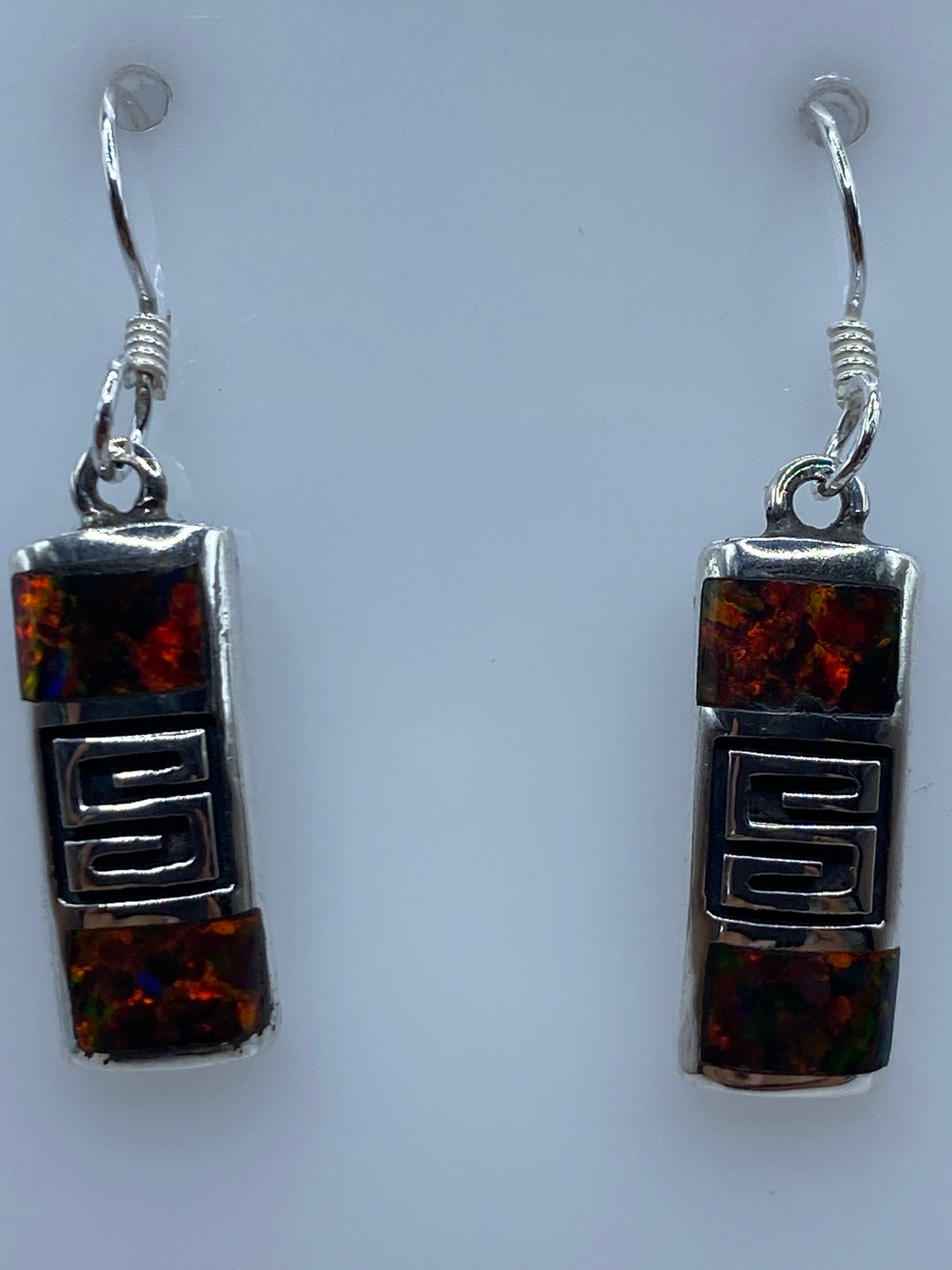 Aretes colgando, mostrando el tamaño de 3 cm y la profundidad del color del ópalo