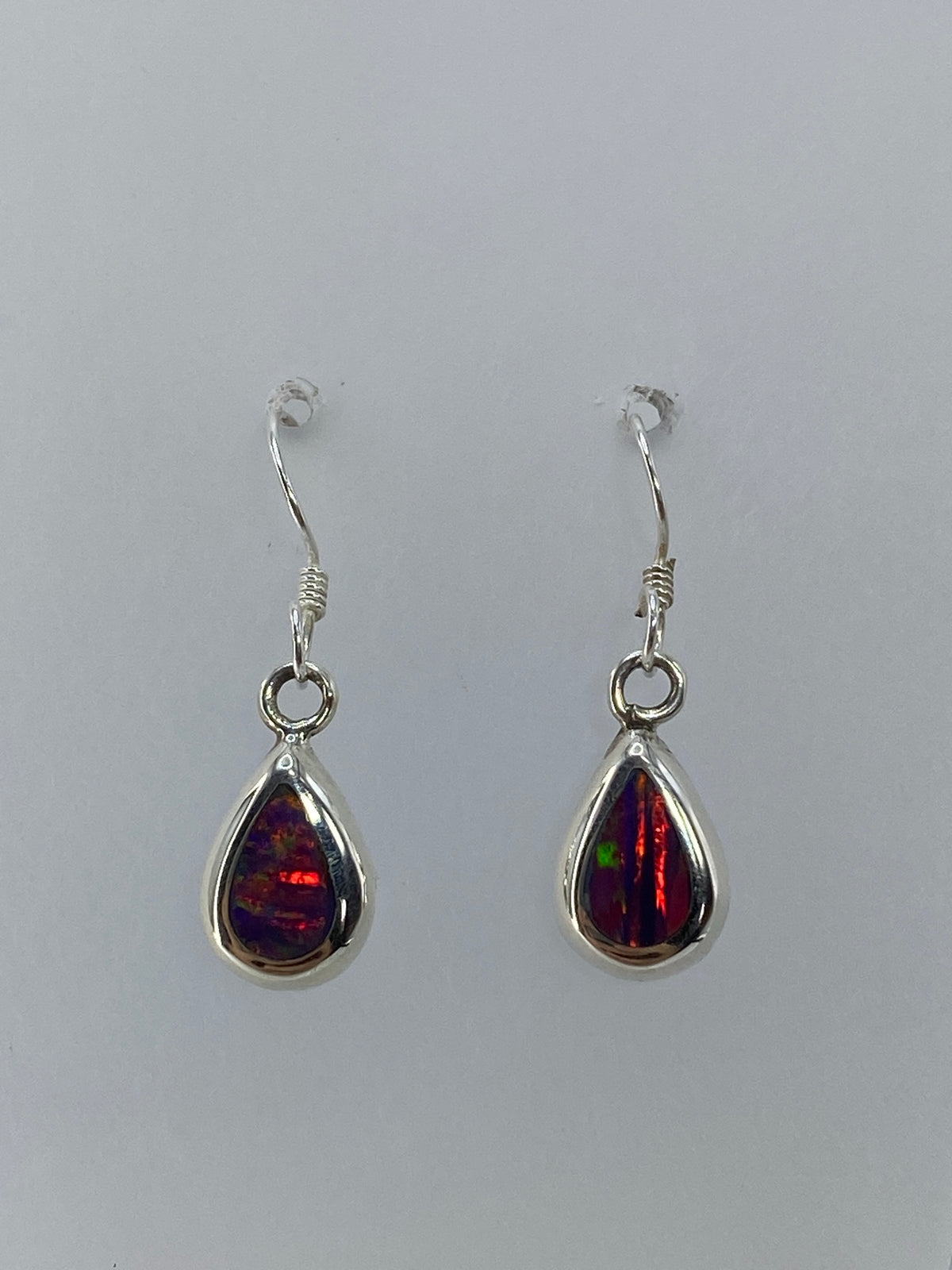 Aretes ópalo de fuego mostrando el brillo rojo y naranja intenso