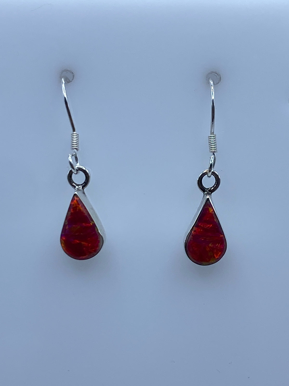Arete de Ópalo de Fuego rosa colgando del gancho francés de plata