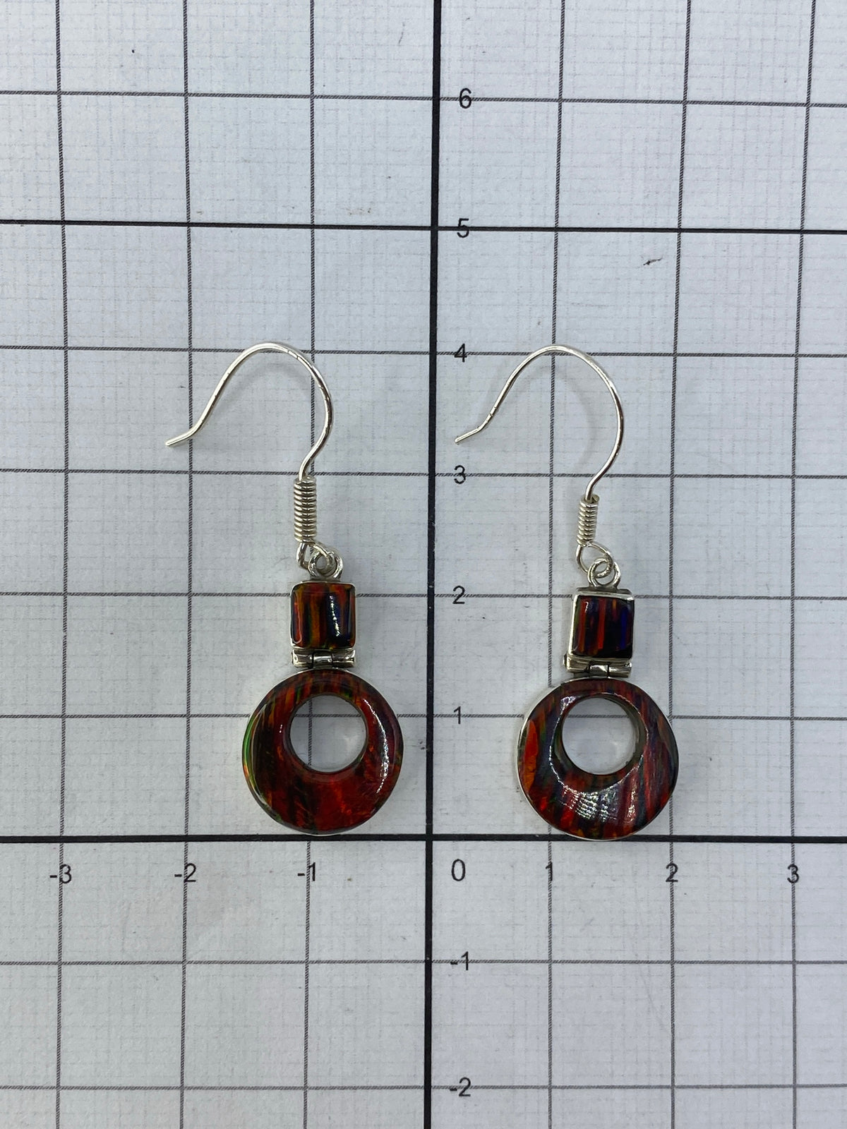 Aretes de lado mostrando los ganchos de plata 950 y el Quinto de autenticidad