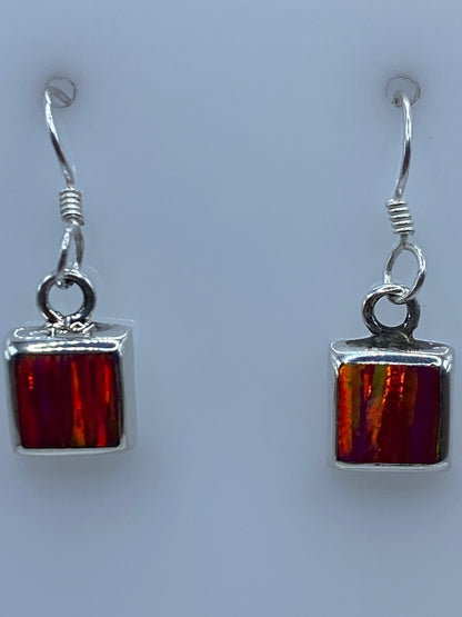 Aretes colgando del gancho de plata, mostrando cómo cae la luz en el opalo