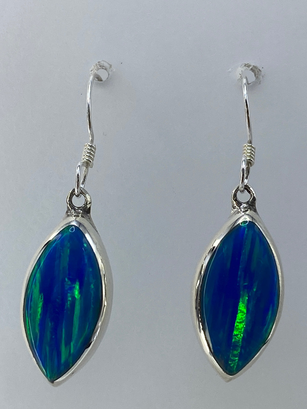 Aretes sobre escala de medición mostrando tamaño real de 3.2 cm
