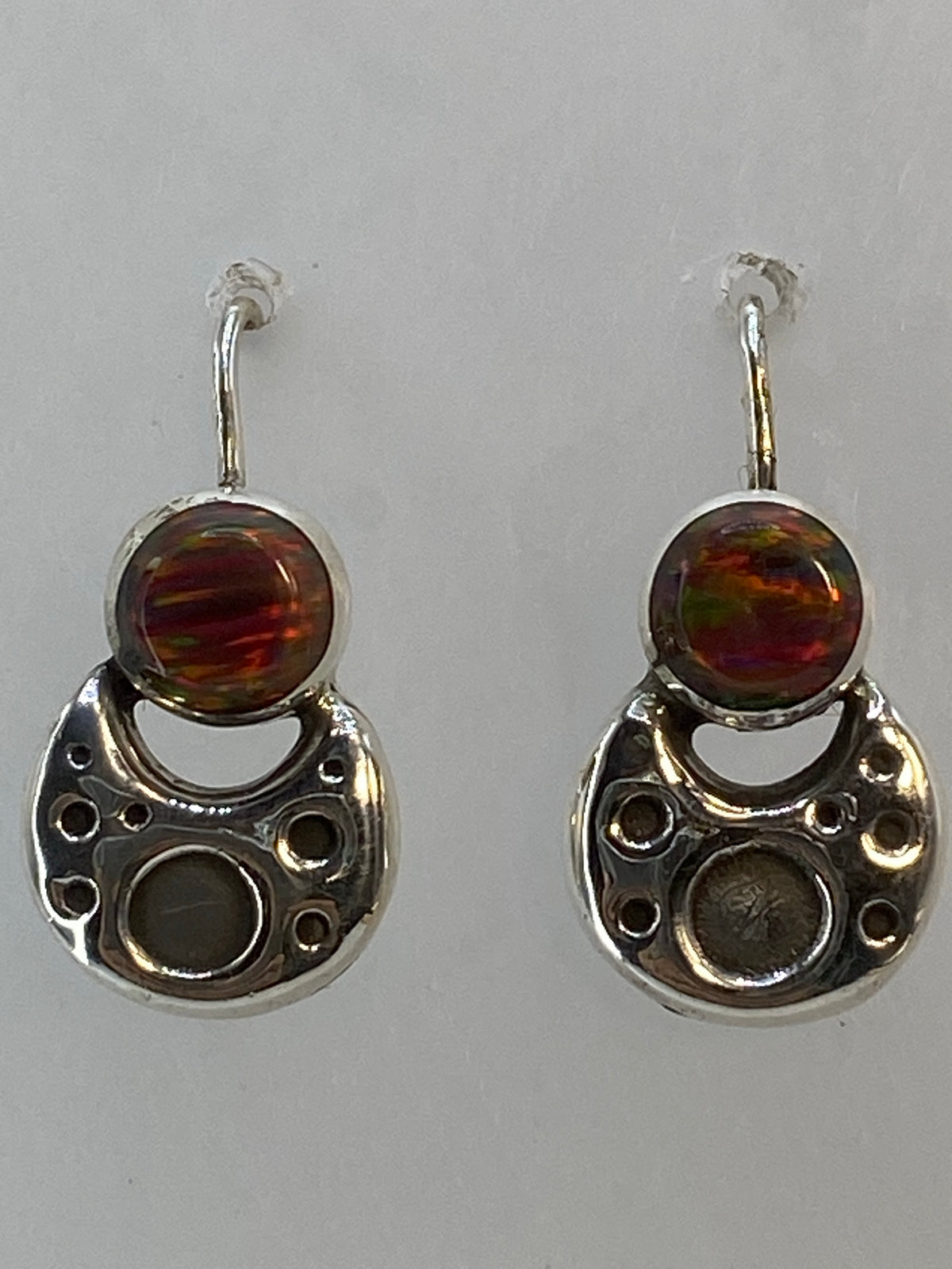 Vista lateral de los aretes delicados de 2 cm con cierre de gancho de plata