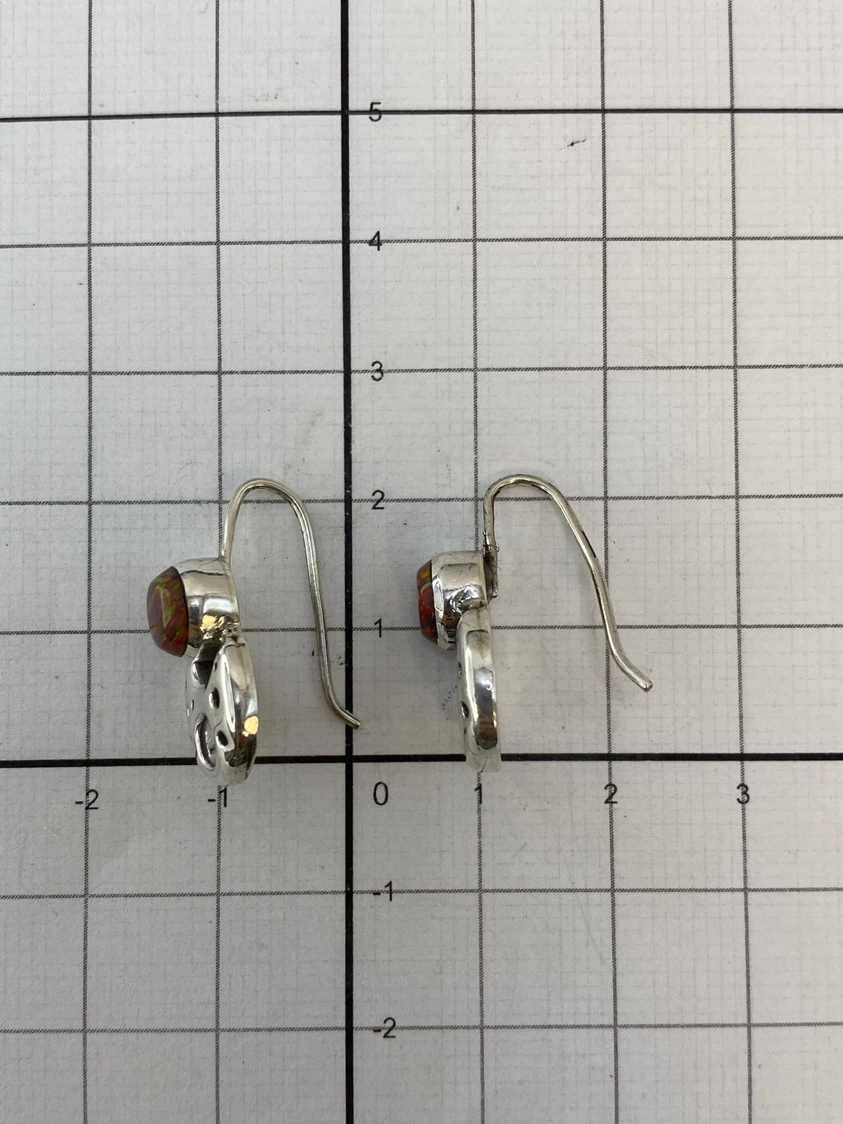 Aretes sobre fondo blanco mostrando el Quinto 950 en la plata
