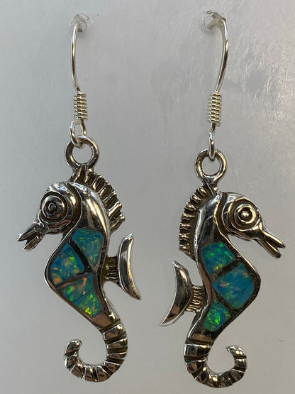 Aretes de plata colgando, vista frontal del par completo en tonos azul cielo
