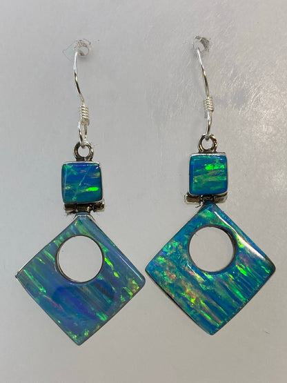 Par de aretes de plata con opalo de fuego multicolor, colgando en gancho de plata