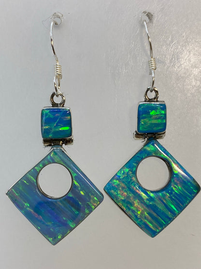 Aretes vistos al trasluz mostrando los tonos azul, verde y naranja del opalo