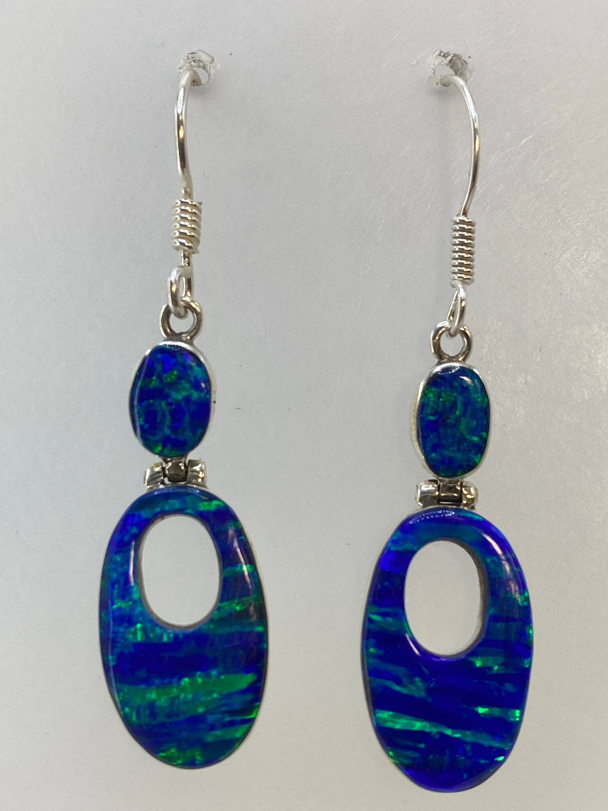 Aretes en la mano mostrando el largo de 4.5 cm y la luz a traves de la piedra