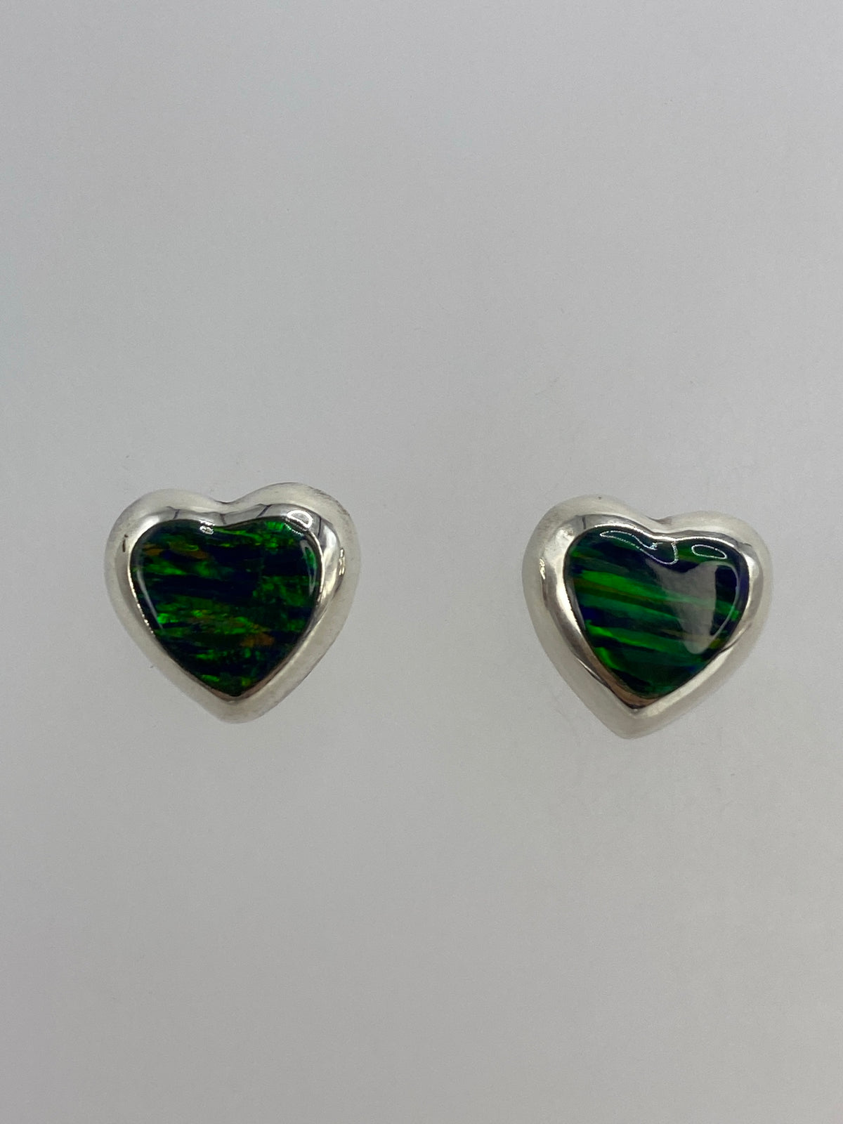 Par de aretes de plata 925 con ópalo de fuego verde engastado, sobre fondo blanco