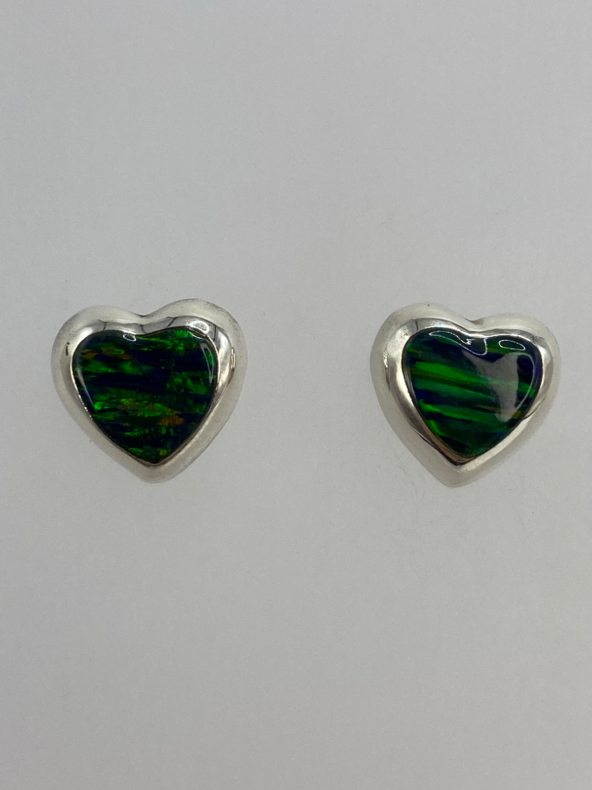 Aretes pequeños de 1.4 cm de largo junto a regla para escala