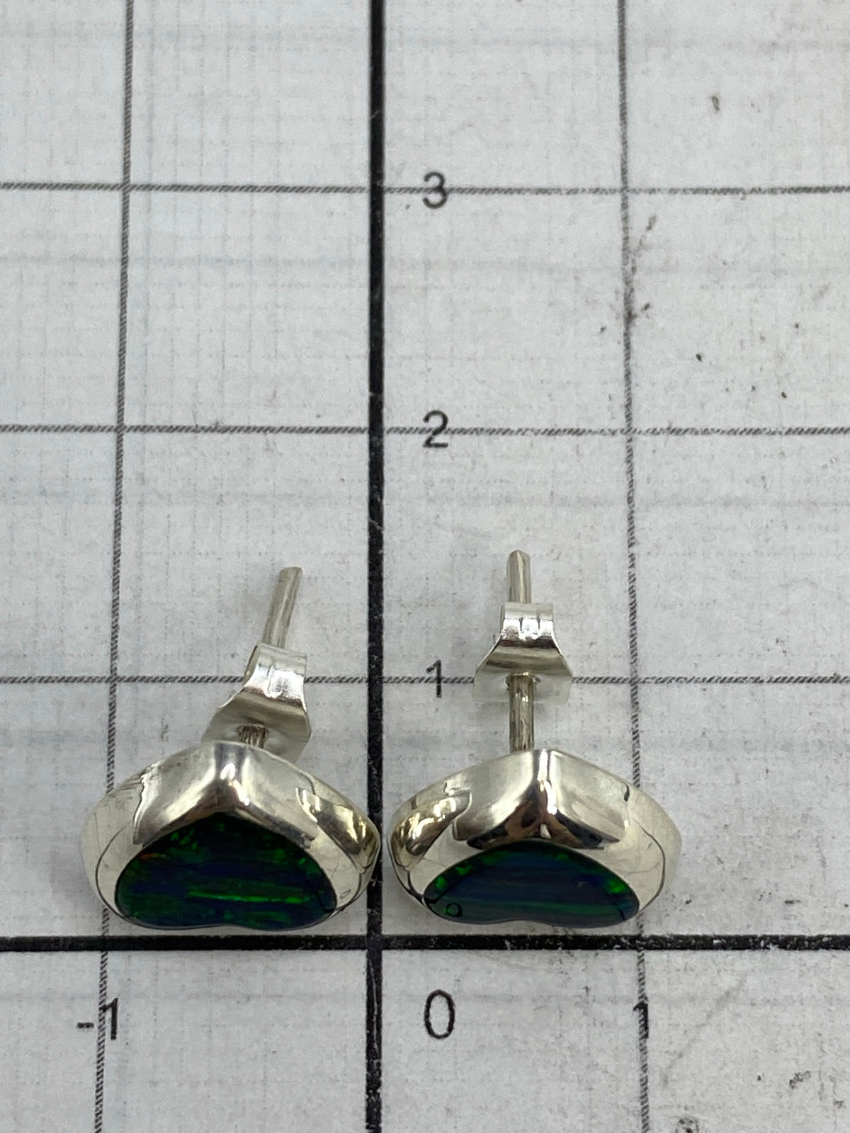 Reverso de los aretes mostrando el Quinto 925 y el poste de plata