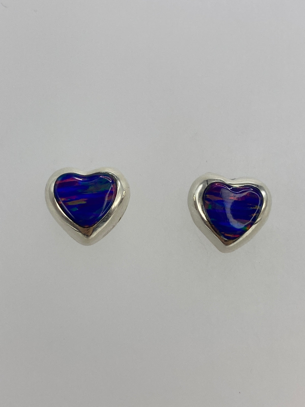 Par de aretes de corazón en plata 925 con ópalo de fuego morada, vista frontal