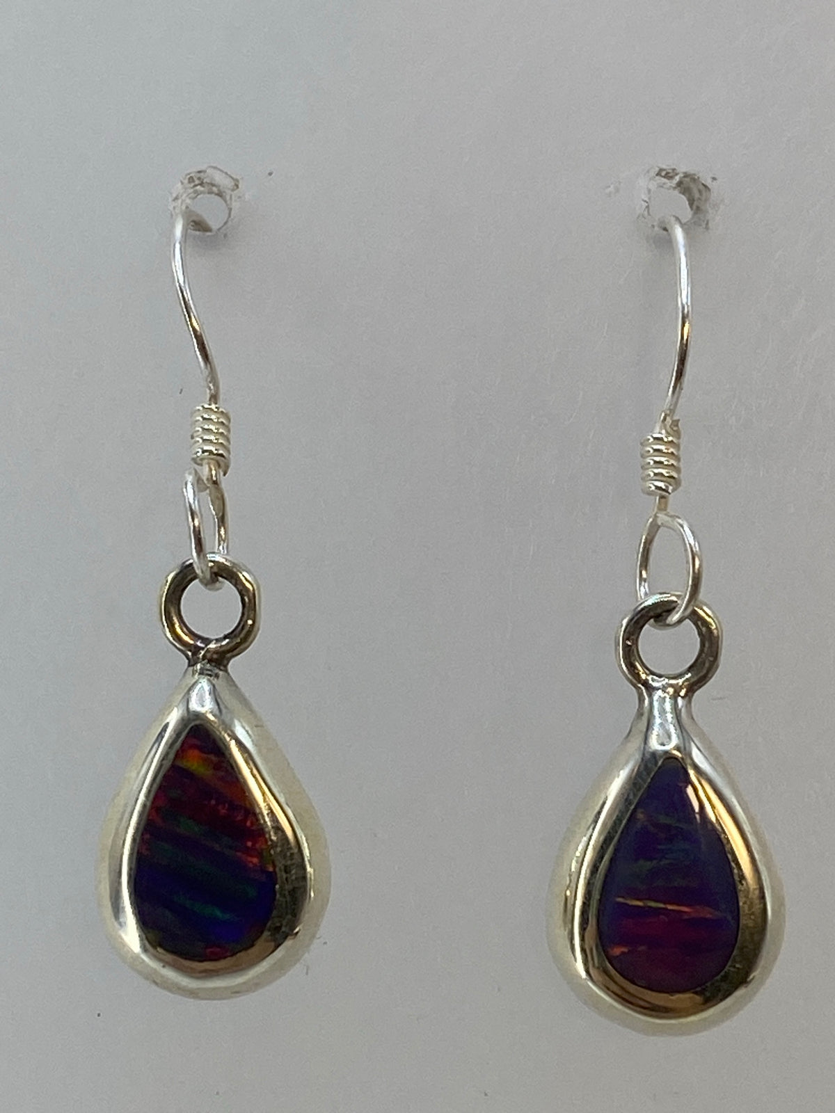 Aretes sobre regla de centímetros marcando el largo de 2.5 cm