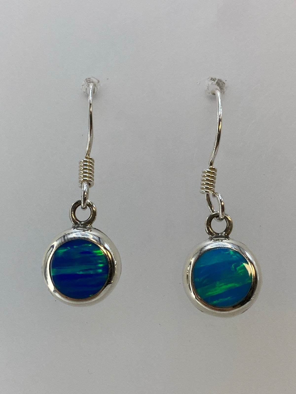 Par de aretes de plata con ópalo de fuego verde limón colgando de ganchos de plata 950