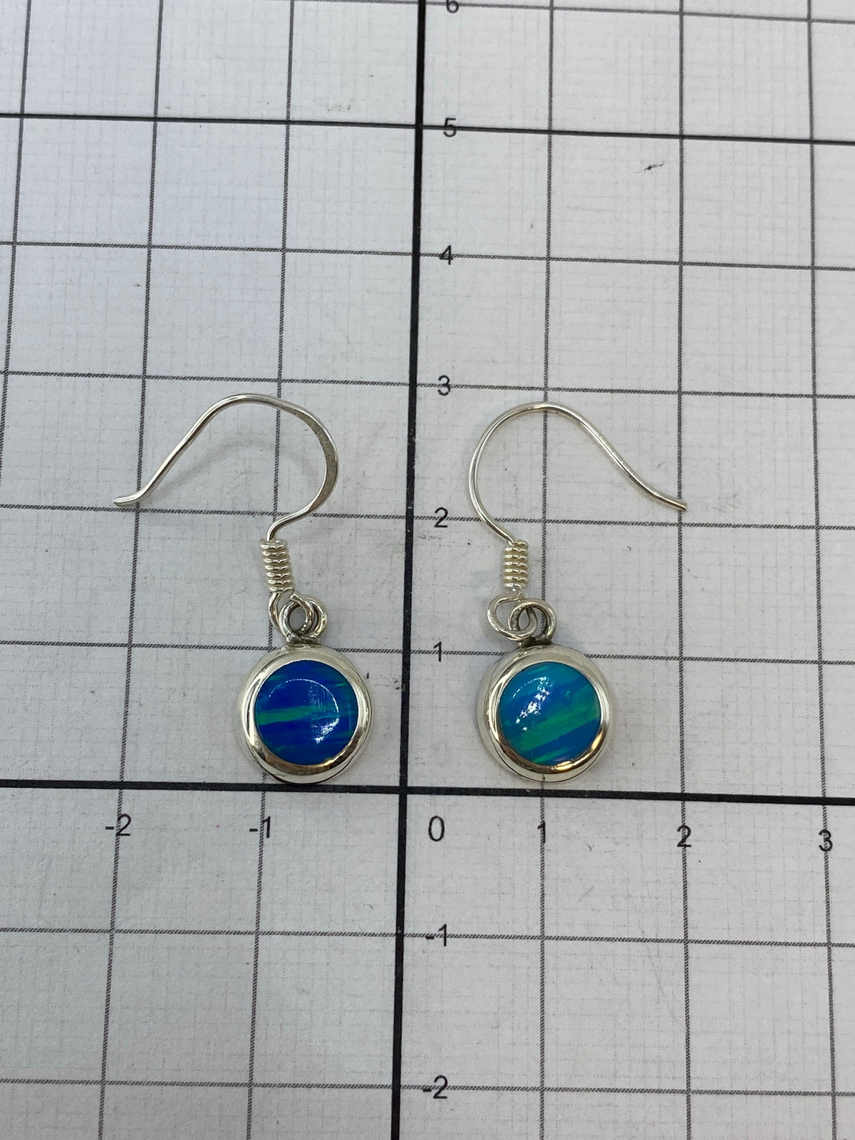 Aretes sobre fondo blanco con el Quinto 950 visible en el metal