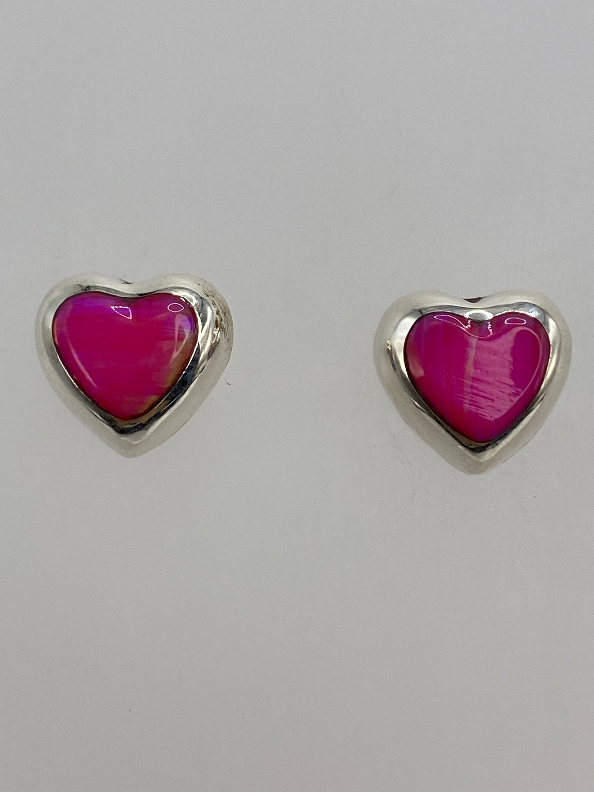 Medida comparativa de los aretes en regla milimetrada, mostrando 1.4 cm de largo