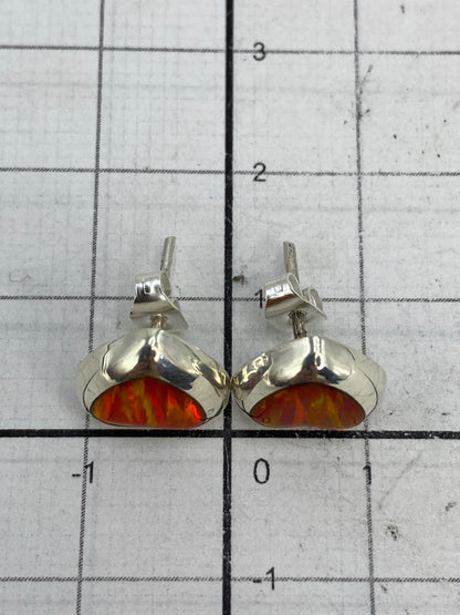 Aretes puestos en oreja mostrando el brillo del Ópalo de Fuego