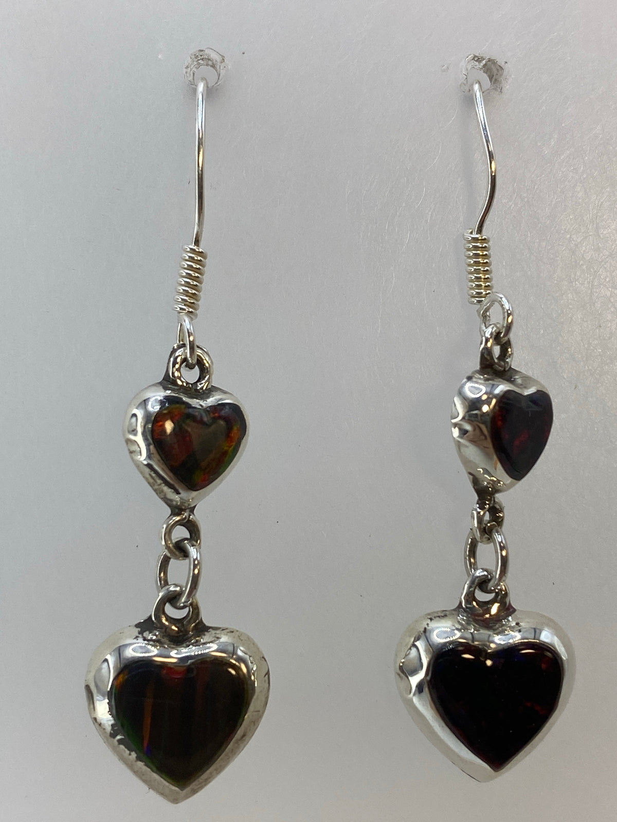 Aretes de ópalo en tonos rojo, naranja y verde sobre fondo blanco