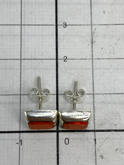 Aretes sobre fondo blanco destacando el color naranja luminoso de la piedra