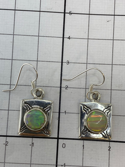 Aretes de ópalo de fuego en gancho de plata 950 sobre fondo blanco con Quinto visible