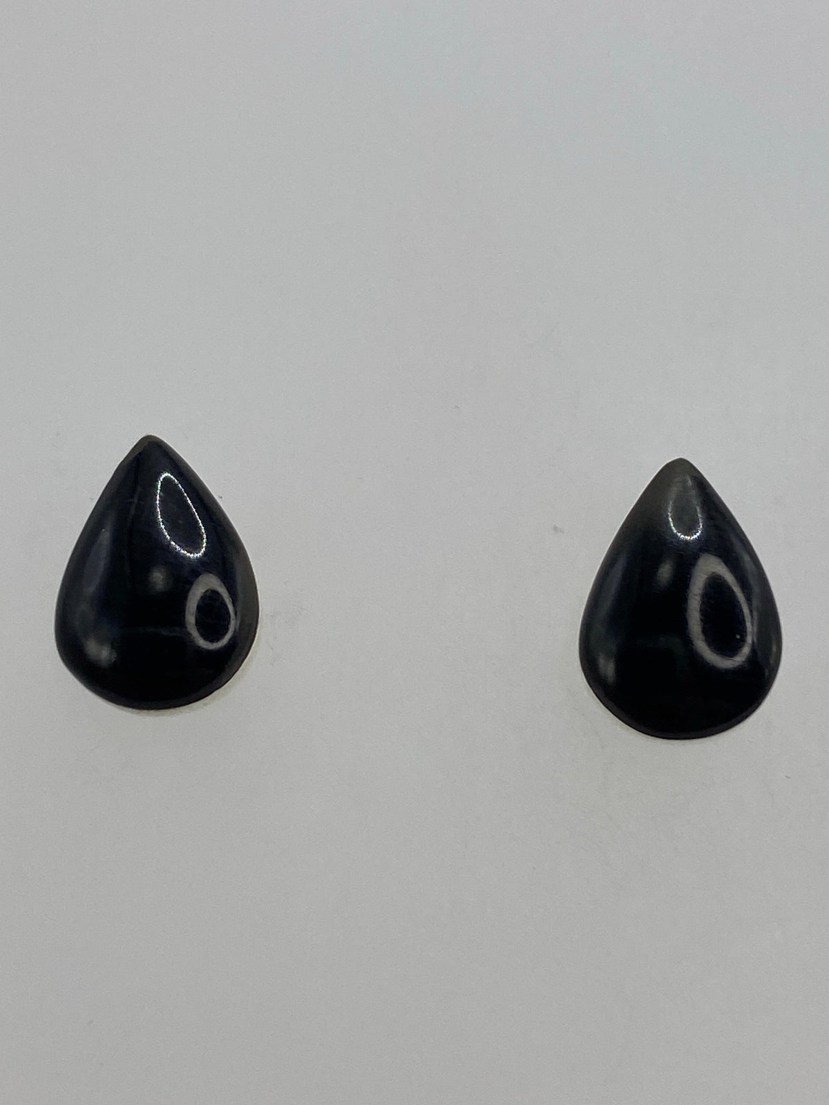 Aretes minimalistas de 1.5 cm sobre fondo azul