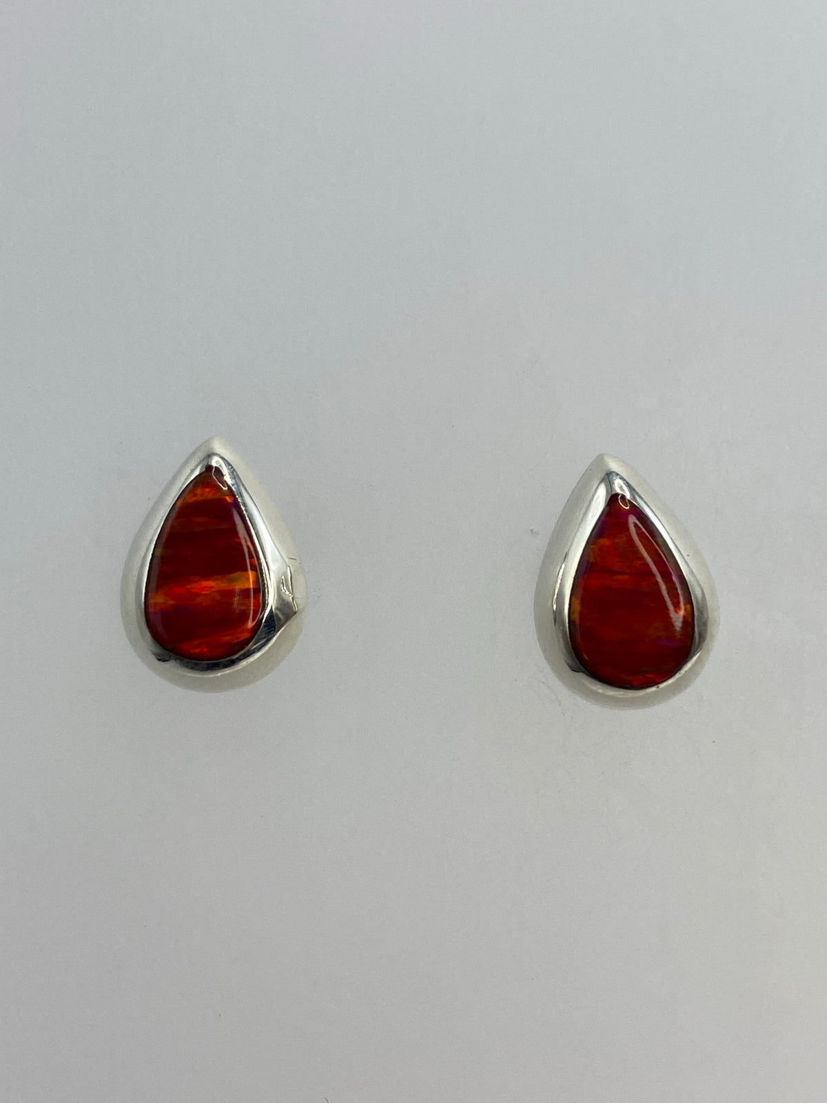 Par de aretes de plata 925 con ópalo de fuego naranja, 1.4 cm, sobre fondo gris