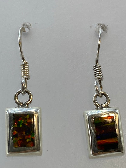 Aretes colgando mostrando el reflejo multicolor del ópalo, ángulo lateral