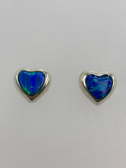 Par de aretes de plata con ópalo de fuego azul en forma de gota, vistos de frente