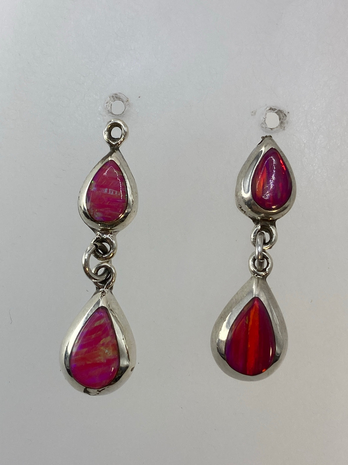 Vista lateral de aretes con ópalo de fuego tono rosa y gancho de plata 925