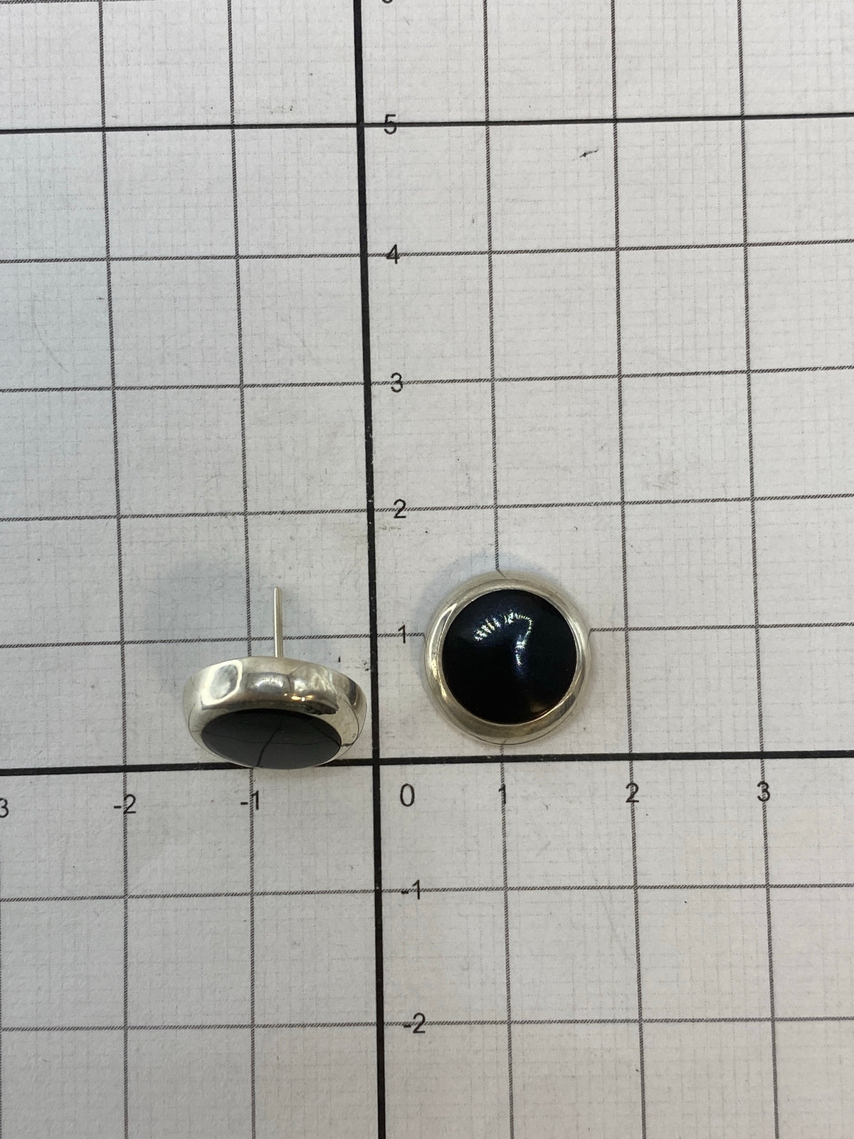 Aretes de Taxco con piedra negra sobre fondo blanco, mostrando el Quinto 925
