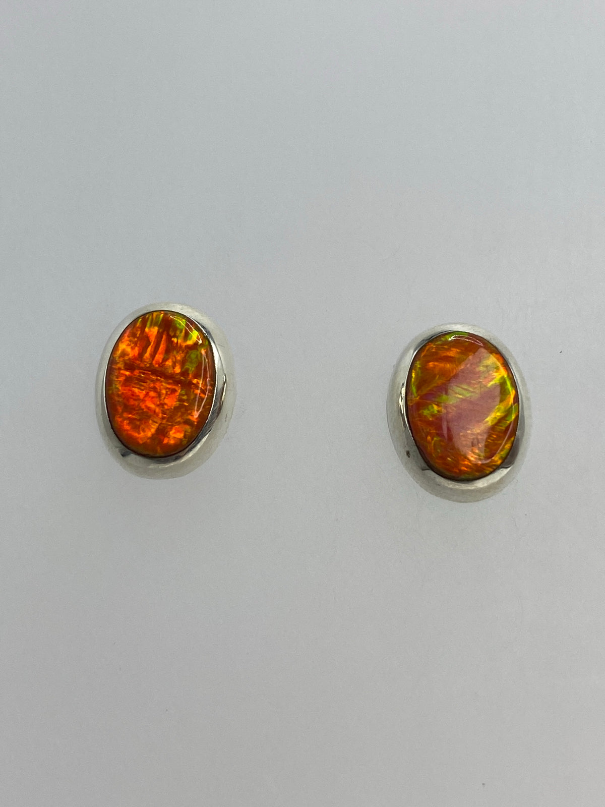 Detalle de los aretes mostrando el brillo naranja-rojo del Opalo de Fuego