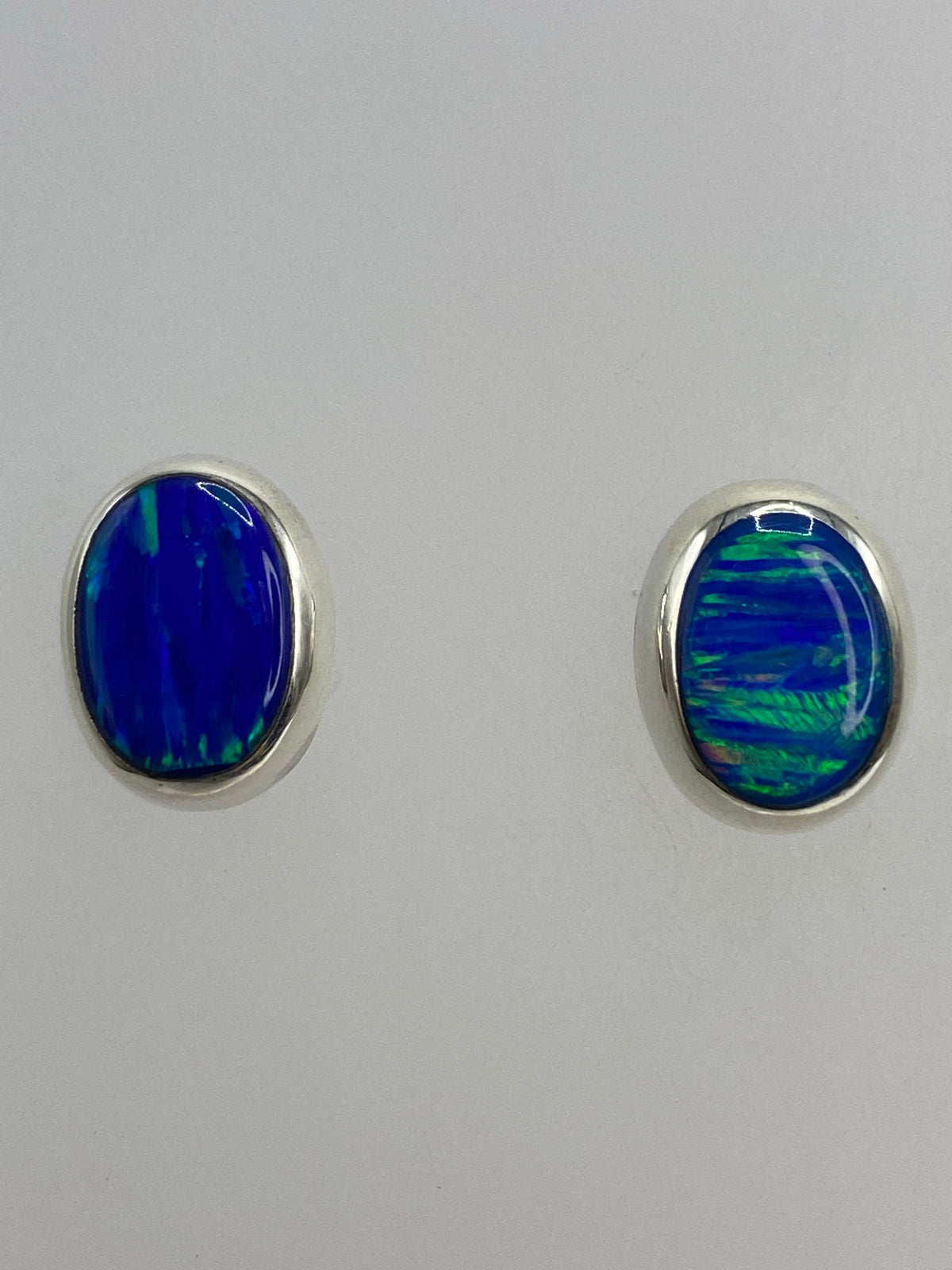 Aretes de ópalo de fuego en escala con regla, mostrando 1.4 cm de largo