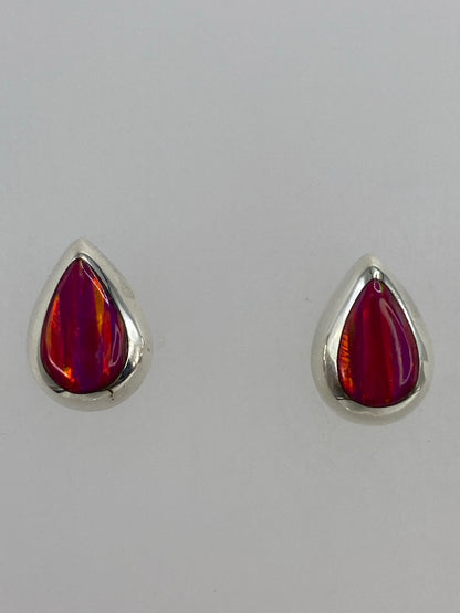Aretes sobre fondo blanco con luz natural resaltando el brillo del ópalo rosa