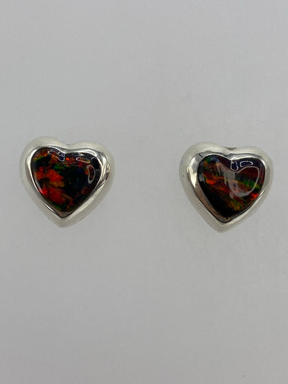 Aretes de ópalo fuego sobre fondo blanco mostrando el Quinto 925