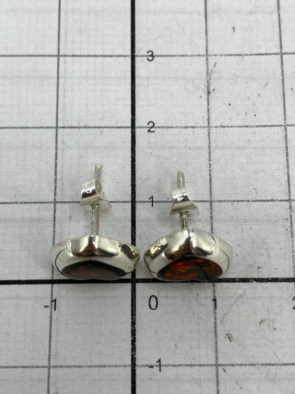 Aretes en mano mostrando el tamaño delicado de 1.4 cm