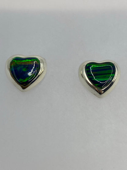 Aretes de plata ópalo de fuego con detalles de color verde y azul bajo luz natural