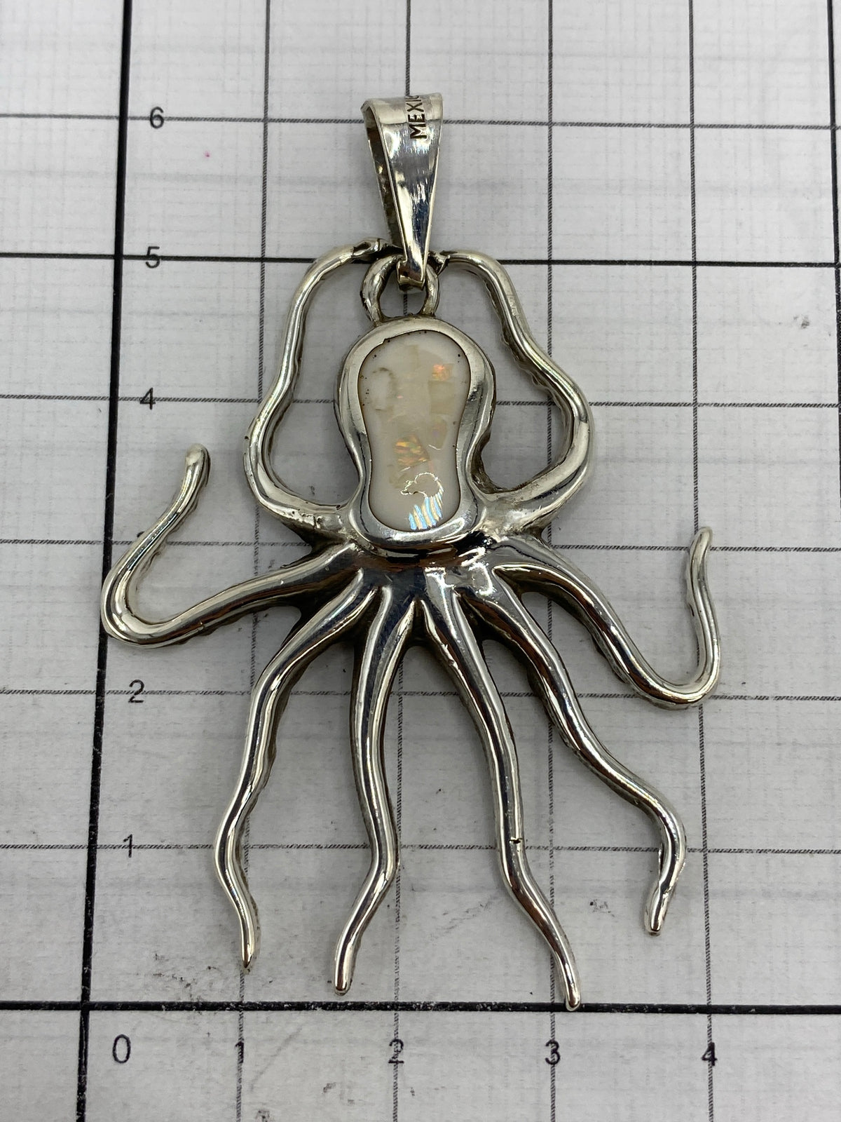Dije pulpo sobre escala de centímetros, midiendo 6.2 cm de largo con Quinto 925 visible