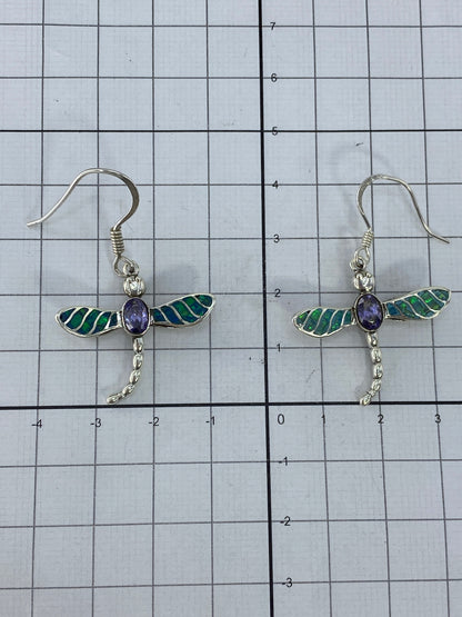 Aretes libelula en la mano mostrando el brillo del Opalo de Fuego verde