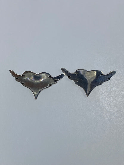 Par de aretes de plata cartoneado con corazón alado, vista frontal